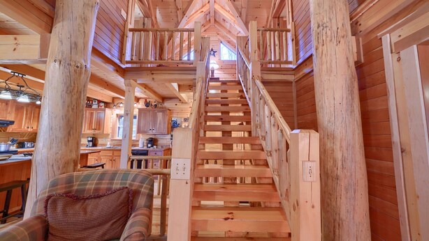 Eine Holztreppe führt zu einer Erkerzone mit Blick auf die Küche darunter.