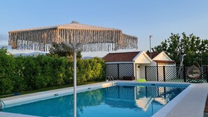 A swimming pool with lounge chairs and a covered area. - Romantic traditional Villa with huge garden, swimming pool, basketball court etc (Avlonas)
