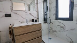 Een douche, een haardroger, handdoeken, toiletpapier