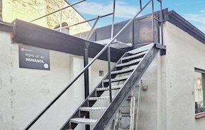 A metal staircase leading to a building entrance with a sign reading 'Hyrs ut av NOVASOL.'