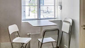A small room with a window, a radiator, and two white chairs. - Cozy apartment in Visby with kitchen (Visby)