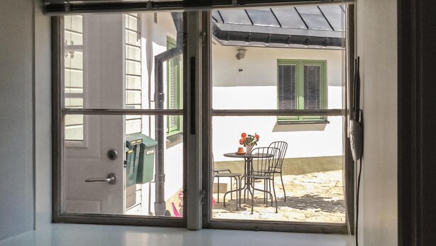 A room with a sliding glass door leading to an outdoor patio area. - Cozy apartment in Visby with kitchen (Visby)