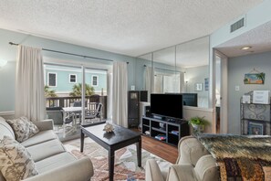 TV, fireplace, books - Oceanfront Charm: Stay by the Sea with Pool (Fernandina Beach)