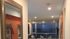 Una cuina moderna amb una illa central, armaris blancs i una finestra gran que ofereix vistes a la ciutat.