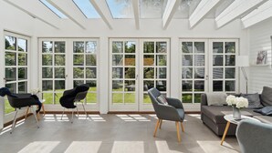 Una habitación amplia con ventanas grandes, tragaluces y una decoración moderna.