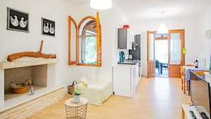 Een kamer met een open haard, een eethoek en een keuken.
