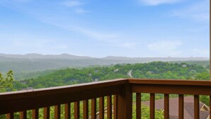 A balcony with a view of a green landscape and distant mountains. - Golf Condo with Fireplace & Jetted Tub at StoneBridge Village (Reeds Spring)