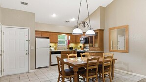 A kitchen with a dining table, chairs, and hanging pendant lights. - Condo with Fireplace and Connecting Suite with Kitchenette (Reeds Spring)