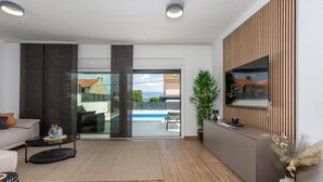 Un salon moderne avec un canapé, une table basse et une vue sur une piscine.