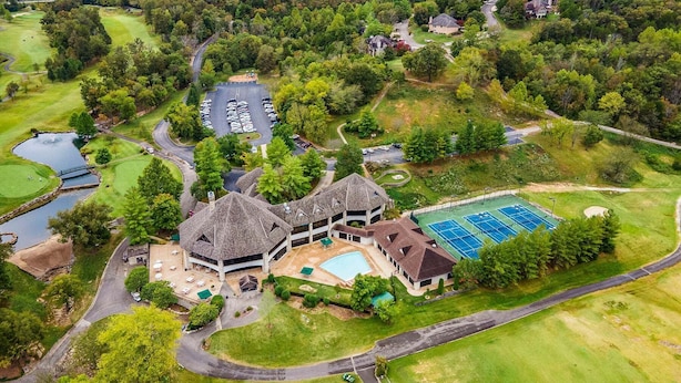 A golf course with a clubhouse, swimming pool, and tennis courts.