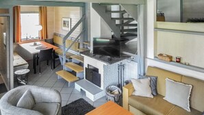 Un espace de vie compact comprenant un coin cuisine, une table à manger et un canapé.