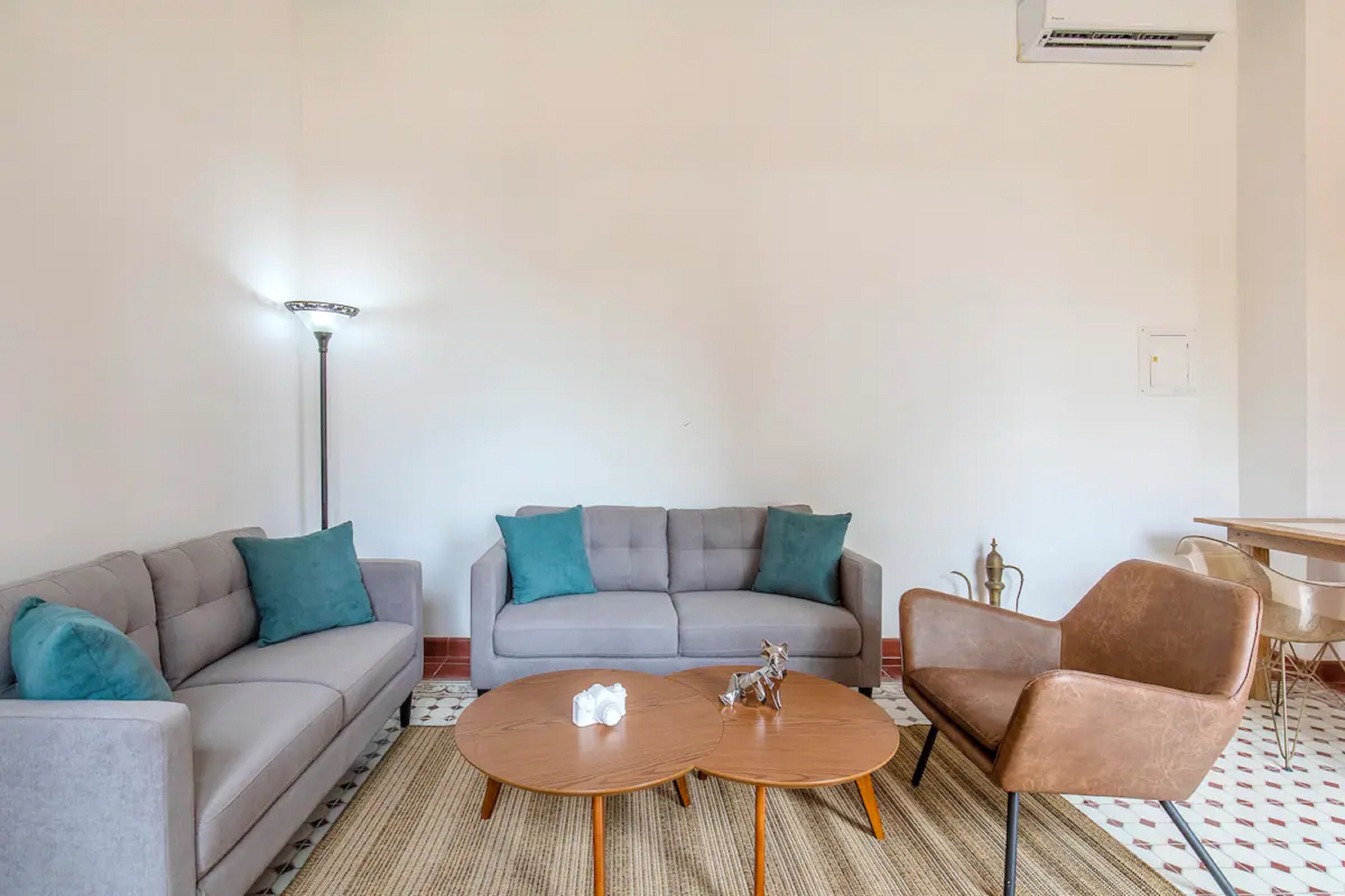 A living room with two sofas, a coffee table, a floor lamp, and a chair.