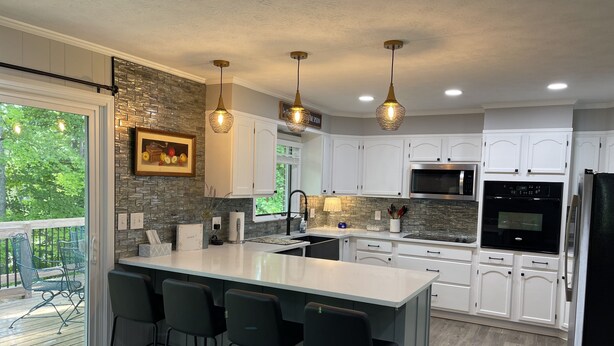 A modern kitchen with a large island, white cabinets, and stainless steel appliances. - Renovated!  Peaceful farm setting.  Close to TTU, town and Cummins Falls. (Cookeville)