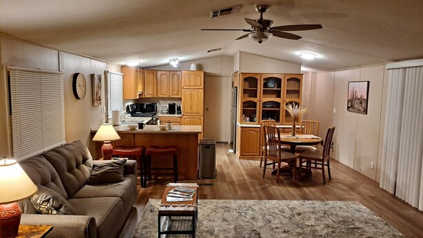 Un espacio habitable compacto con kitchenette, comedor y zona de estar.