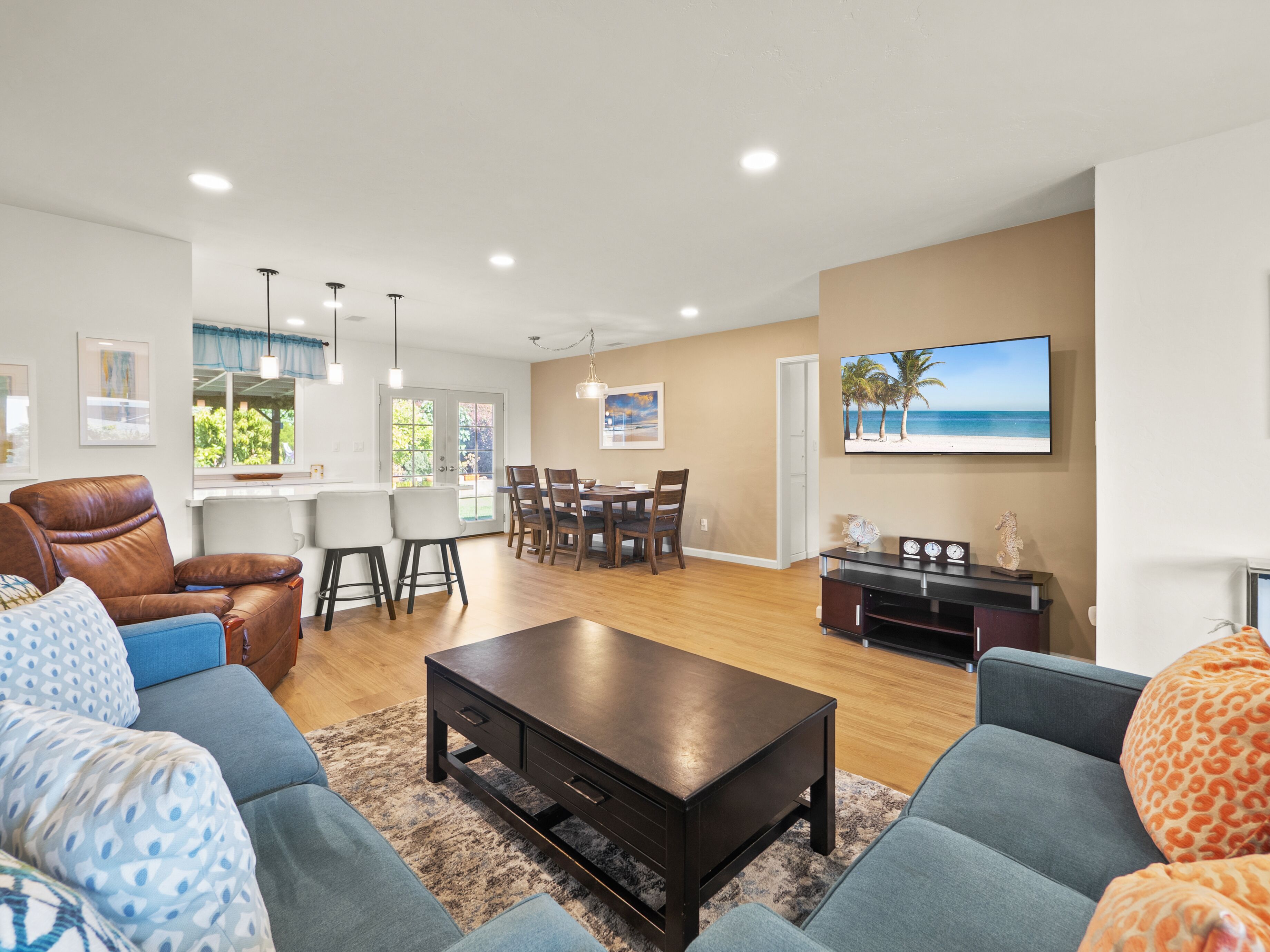 A modern living room with a sofa, coffee table, and dining area.