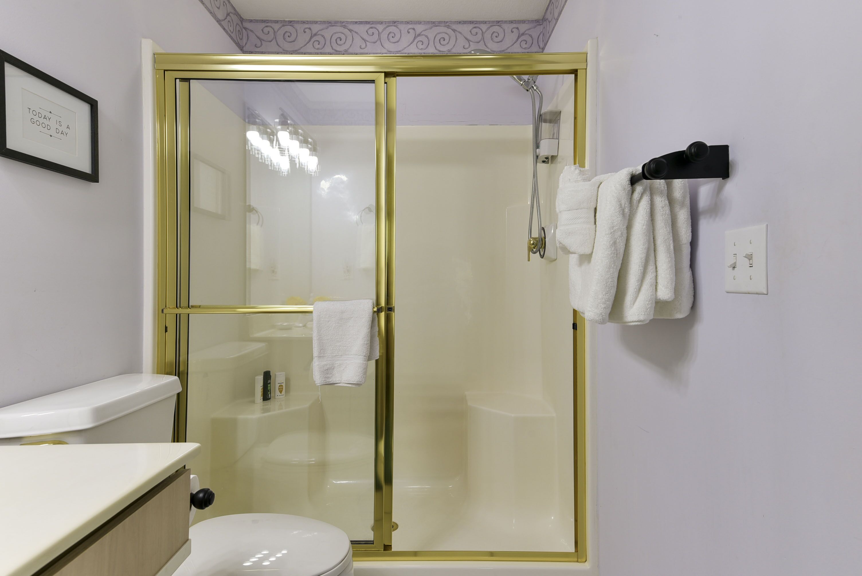 Un baño con ducha de vidrio, inodoro y lavamanos.