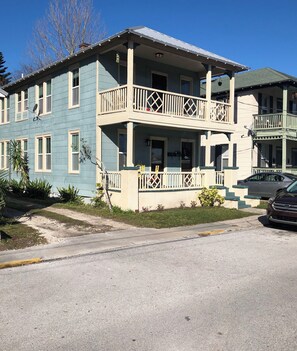 A two-story building with a balcony on the ground floor and a covered porch. - Downtown Lodge-Clean-Pet Friendly-Free Parking (St. Augustine)