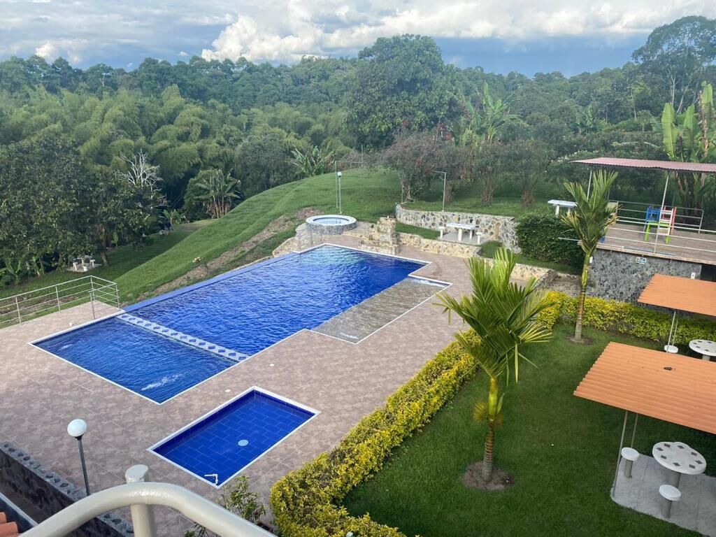 A swimming pool with a view of a lush green landscape and a stone structure.