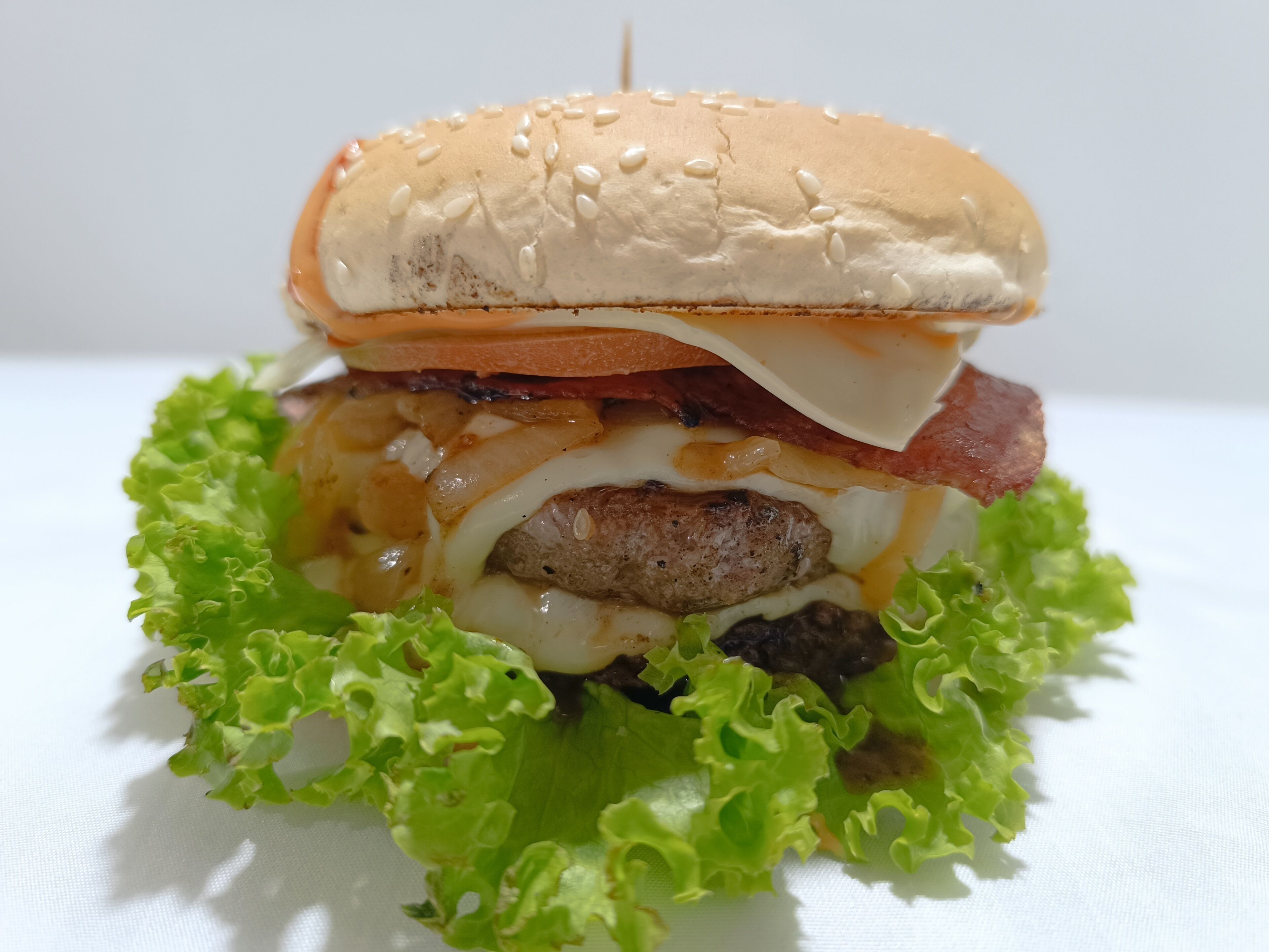 A burger with lettuce, cheese, and a bun.