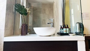 A bathroom with a large mirror, a white sink, and a shower area. - Sea Sand 2 Hotel (Da Nang)