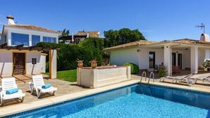 A swimming pool with lounge chairs, a small bar area, and a view of surrounding buildings. - Modern Elegance/Private Pool (Fuengirola)