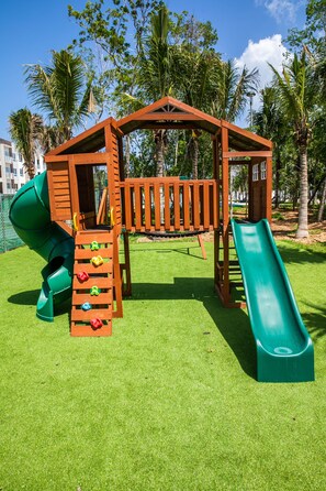 Kids can play on the playground with a slide, climbing area, and swing set.