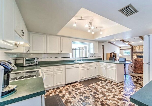 Enjoy cooking in this well-equipped kitchen with a central island, stove, oven, and microwave.