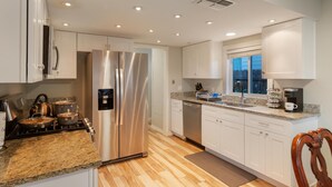 A modern kitchen with stainless steel appliances, white cabinets, and a granite countertop. - Cozy&Tranquil Heaven With KingSuite&Covered Patio&BigFencedYard, 5-Star-Location (Austin)