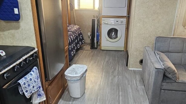A compact RV kitchen with a refrigerator, stove, and washing machine.