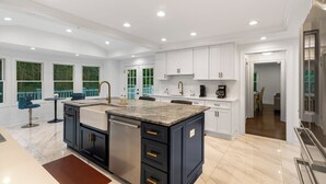 A spacious kitchen with white cabinets, a central island, and a dishwasher. - Estate 5BR 3.5Bath with IGLOO, Game Rm, Fire Pit sleeps 16- 5min Princeton dwtn (Princeton)