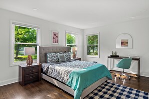 A bedroom with a bed, nightstands, a desk, and a chair. There are windows with views of trees. - Estate 5BR 3.5Bath with IGLOO, Game Rm, Fire Pit sleeps 16- 5min Princeton dwtn (Princeton)