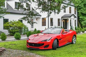 A red sports car parked in front of a white house with a porch and a small garden. - Estate 5BR 3.5Bath with IGLOO, Game Rm, Fire Pit sleeps 16- 5min Princeton dwtn (Princeton)
