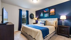 Een slaapkamer met een bed, nachtkastjes, een televisie en kunst aan de muur.