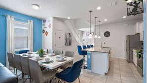 A modern kitchen with a central island, white cabinets, and a stainless steel refrigerator. - Fabulous 7 bed pool home, gated community with FREE ACCESS to resort facilities! (Kissimmee)