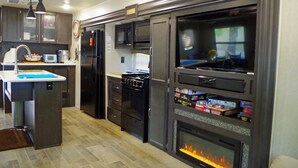 Une cuisine moderne équipée d’un four, d’un micro-ondes et d’un réfrigérateur encastrés.