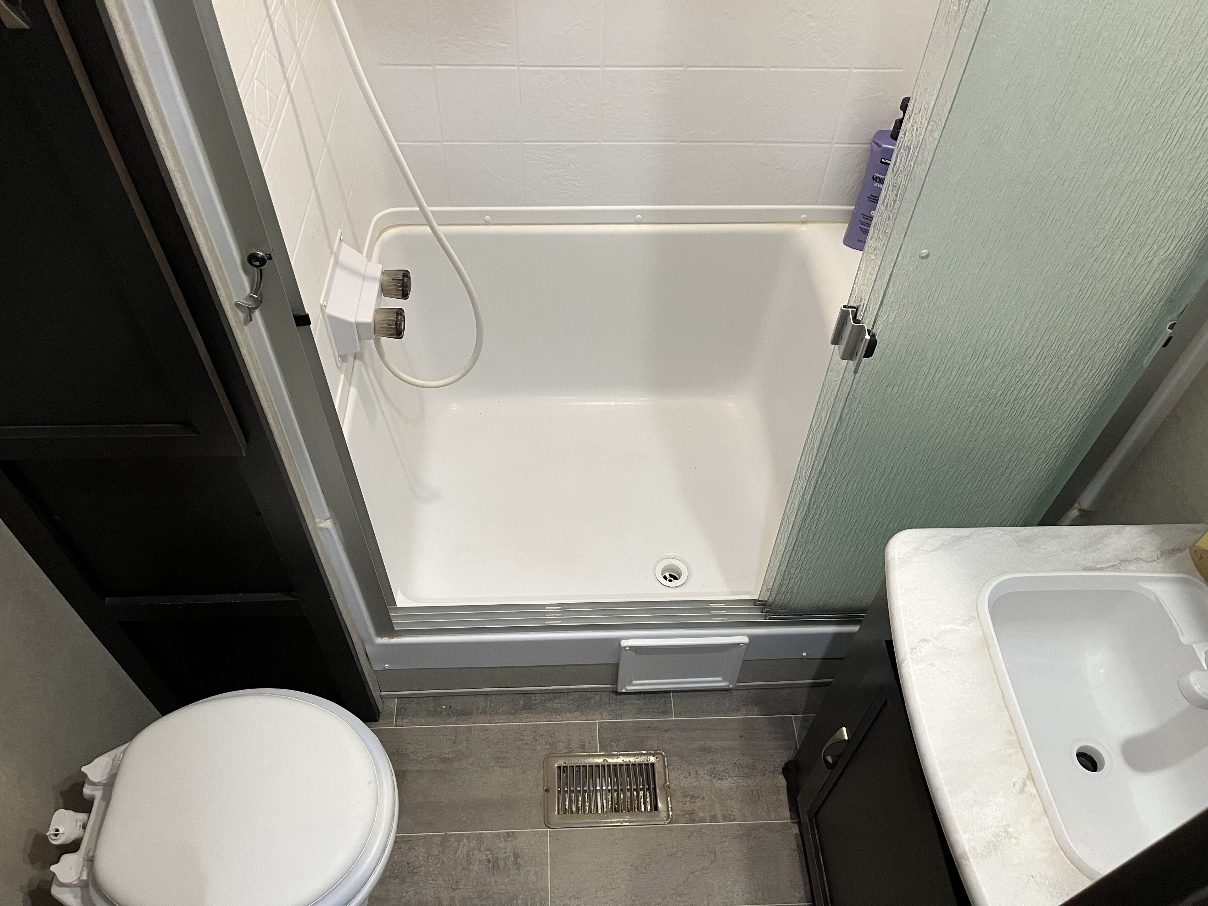 Un bagno piccolo con un WC, una doccia e un lavandino.