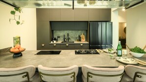 A modern kitchen with a central island, a built-in oven, and a refrigerator. - Sophisticated Tel Aviv Retreat 1BR Apt (Tel Aviv)