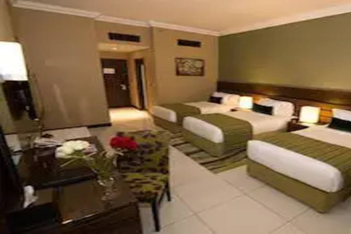 Habitación de hotel con dos camas, un escritorio y una silla.