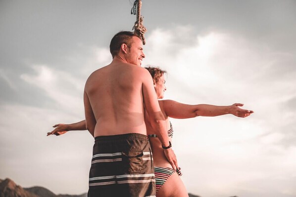Un homme et une femme se tiennent à l’extérieur, peut-être sur une plage, et une corde est suspendue en arrière-plan.