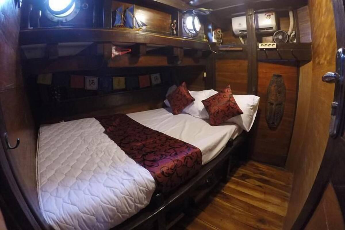 Ein gemütliches, hölzernes Blockhaus mit Etagenbett, einer kleinen Ablagefläche mit Dekoration und einer Holztür.