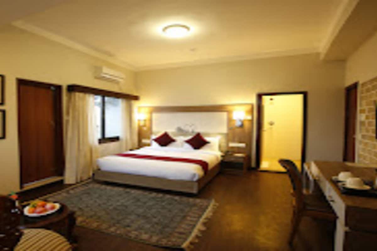 Ein Hotelzimmer mit Bett, Schreibtisch, Stuhl und einem kleinen Tisch mit Obstplatte.