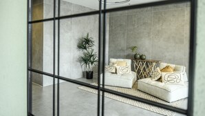 A modern living room with a sofa set, a potted plant, and a geometric-patterned rug. - Spacious 3BR Apt w Garden Ramat Hasharon (Ramat Hasharon)