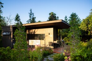Surrounded by lush greenery, the lobby features large windows and a flat roof.