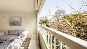 Ein Balkon mit Blick auf eine Stadtlandschaft und Bäume.