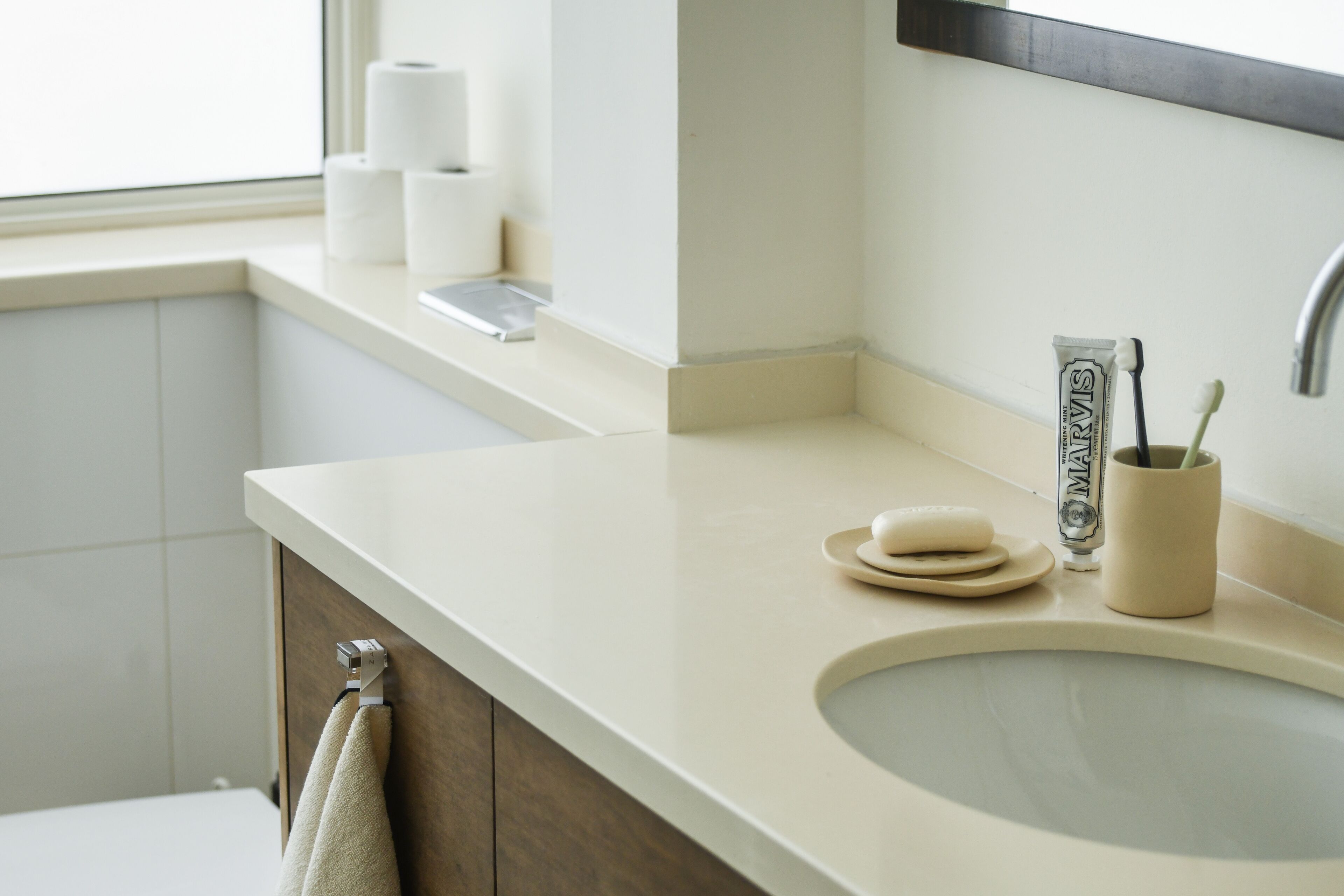 A bathroom with a sink, toilet, and towel rack.