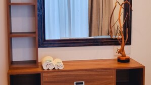 Een houten wastafel met spiegel, plank en lade.