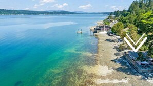 A coastal property with a clear view of the sea, a dock, and a small building. - Keys on the Canal - Stunning Beachfront Bungalow! (Belfair)