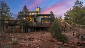 Une maison moderne dotée d’une terrasse, d’un espace extérieur couvert et d’un escalier menant à un deuxième étage.