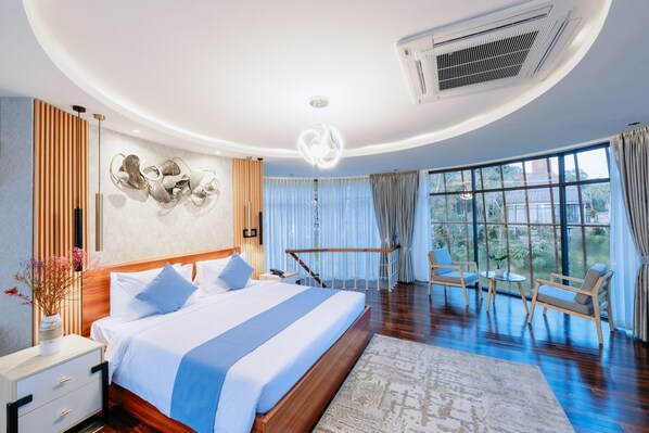 Une chambre d’hôtel moderne dotée d’un grand lit, d’un coin salon et offrant une vue sur l’extérieur.