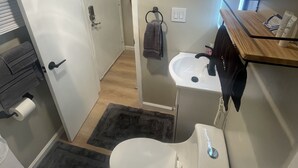 Kylpyhuone, jossa on wc, pesuallas ja pyyheteline.